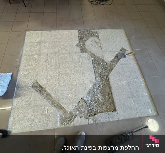 רצפה עם אריחים שבורים וכלי עבודה לשיפוץ